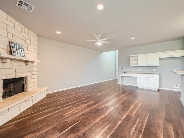 unfurnished living room with ceiling fan, a fireplace, and dark hardwood / wood-style floors