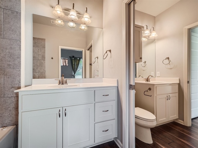 bathroom with hardwood / wood-style floors, vanity, and toilet