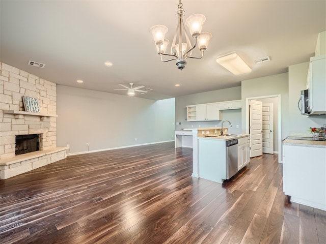 kitchen with appliances with stainless steel finishes, dark wood-type flooring, pendant lighting, a center island with sink, and white cabinets