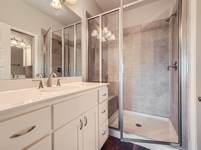 bathroom with hardwood / wood-style floors, vanity, and a shower with shower door