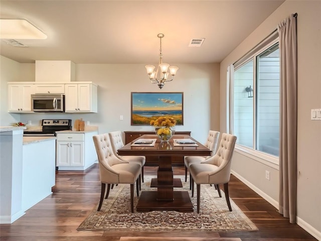 dining area with dark hardwood / wood-style flooring, a wealth of natural light, and a chandelier