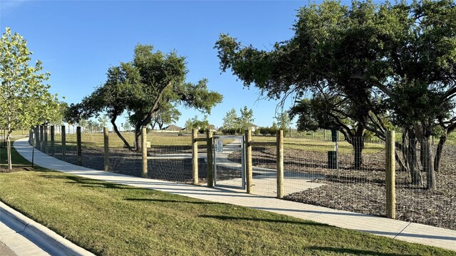 view of community with a lawn and a rural view