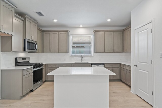 kitchen featuring gray cabinets, stainless steel appliances, and light hardwood / wood-style floors