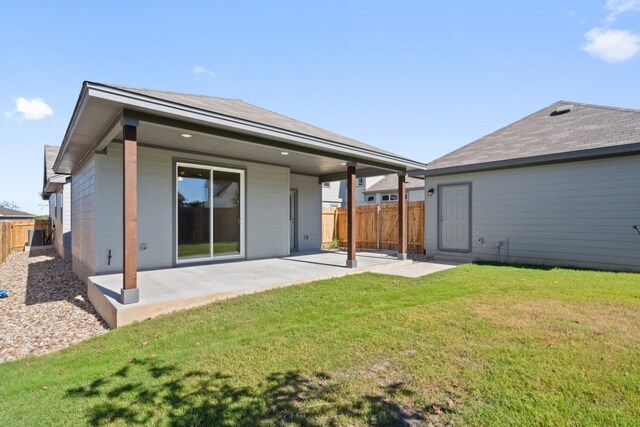 back of house with a patio area and a lawn