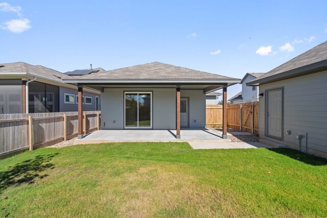 back of property with a patio area and a lawn