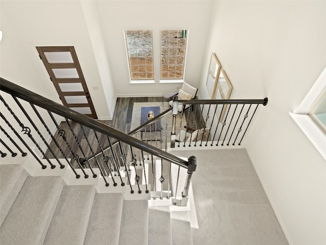 stairway featuring hardwood / wood-style flooring and a high ceiling