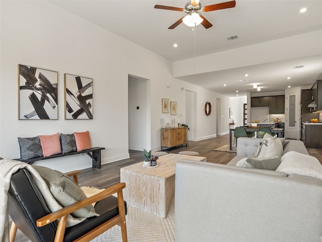 living room with ceiling fan and dark wood-type flooring