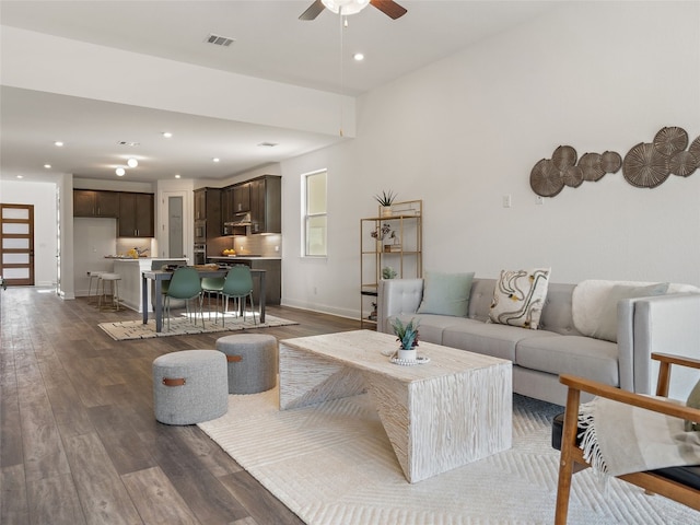 living room featuring ceiling fan and dark wood-type flooring