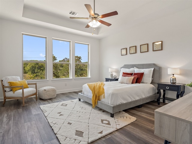 bedroom featuring a tray ceiling, ceiling fan, and hardwood / wood-style flooring