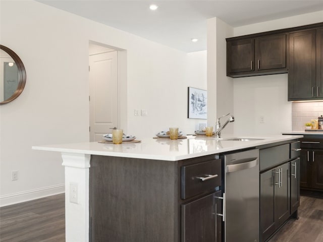 kitchen featuring tasteful backsplash, dark wood-type flooring, a center island with sink, and dishwasher