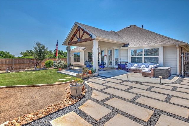 back of property featuring outdoor lounge area, a lawn, and a patio