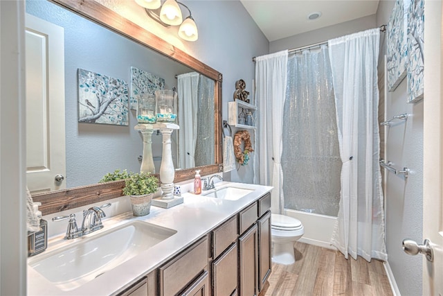 full bathroom with vanity, toilet, hardwood / wood-style flooring, and shower / tub combo