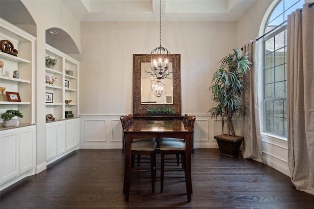 dining space featuring dark wood-type flooring and an inviting chandelier