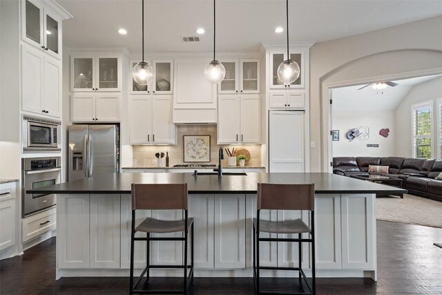 kitchen with decorative backsplash, white cabinetry, dark hardwood / wood-style floors, and stainless steel appliances