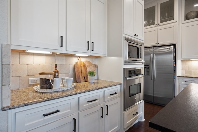 kitchen featuring white cabinetry, backsplash, stainless steel appliances, and dark hardwood / wood-style floors