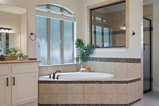 bathroom featuring tile patterned flooring, vanity, a healthy amount of sunlight, and shower with separate bathtub