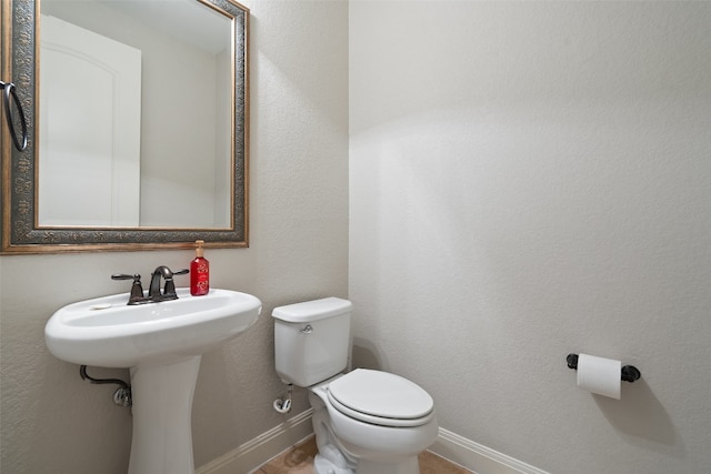 bathroom featuring toilet and tile patterned flooring