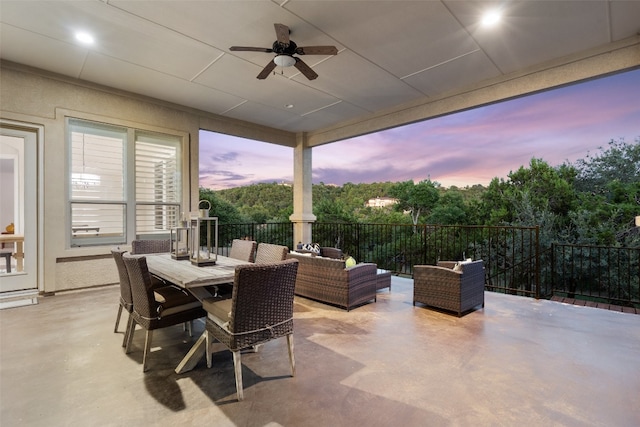 patio terrace at dusk with an outdoor living space and ceiling fan