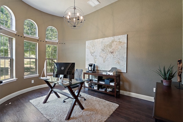 office with high vaulted ceiling, an inviting chandelier, and dark wood-type flooring