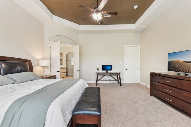 1104 Lions Lair, Leander, TX 78641 - bedroom featuring a raised ceiling, light colored carpet, arched walkways, and a ceiling fan