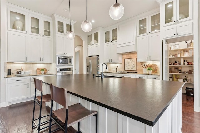 1104 Lions Lair, Leander, TX 78641 - kitchen with stainless steel appliances, arched walkways, dark wood-style floors, decorative backsplash, and recessed lighting