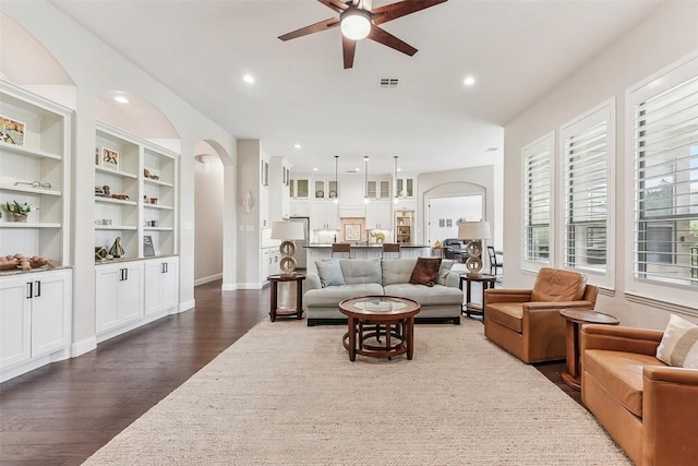 1104 Lions Lair, Leander, TX 78641 - living room featuring ceiling fan, dark wood-type flooring, arched walkways, recessed lighting, and built in shelves
