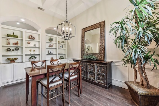 1104 Lions Lair, Leander, TX 78641 - dining room featuring a chandelier, dark wood-style flooring, built in shelves, and wainscoting
