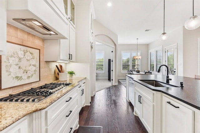 1104 Lions Lair, Leander, TX 78641 - kitchen featuring stainless steel gas cooktop, dark wood-style flooring, tasteful backsplash, premium range hood, and white cabinetry