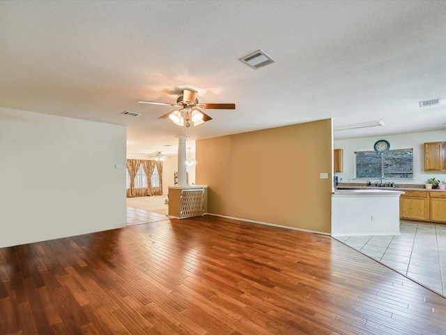905 E Olympic Dr, Pflugerville, TX 78660 - unfurnished living room featuring ceiling fan and light wood-style flooring