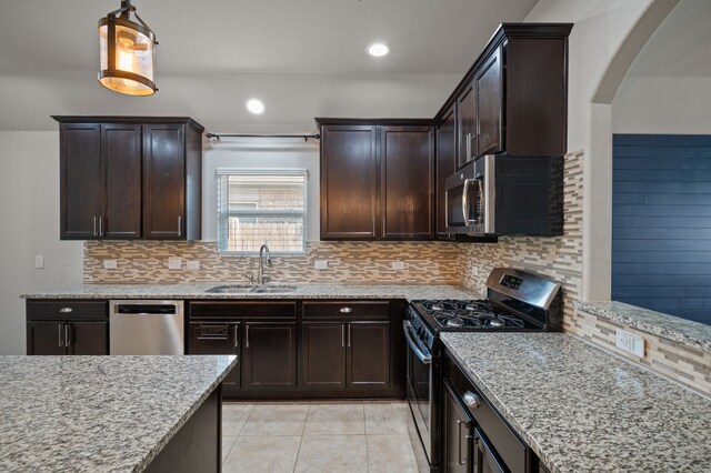 kitchen with sink, stainless steel appliances, decorative backsplash, and light tile patterned floors