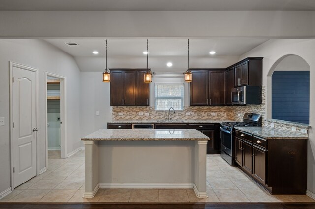 kitchen with appliances with stainless steel finishes, backsplash, sink, light stone countertops, and light tile patterned flooring