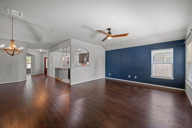 unfurnished living room featuring ceiling fan with notable chandelier and hardwood / wood-style floors