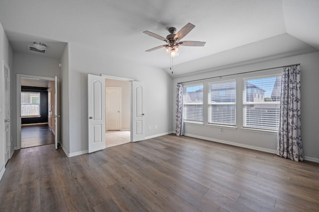 unfurnished bedroom with ceiling fan, multiple windows, and wood-type flooring