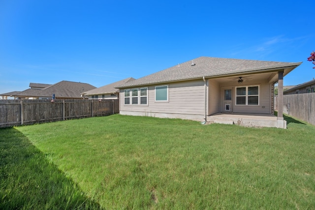 back of property with ceiling fan, a patio, and a yard