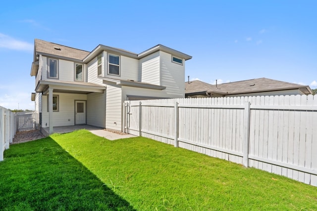 back of property with a yard and a patio area