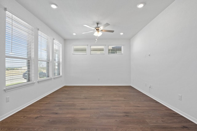 unfurnished room with a healthy amount of sunlight, ceiling fan, and dark hardwood / wood-style flooring