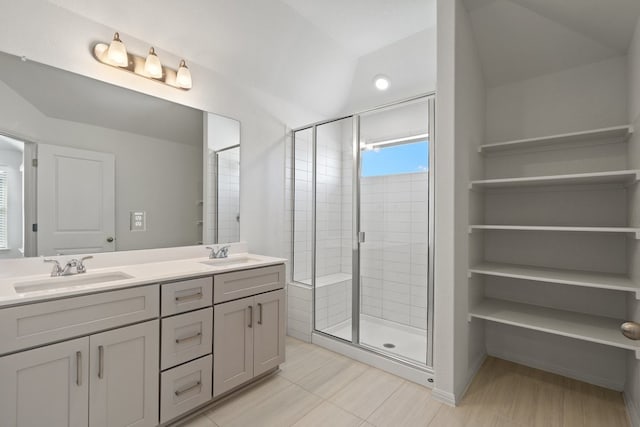 bathroom featuring a shower with door, lofted ceiling, vanity, and tile patterned floors