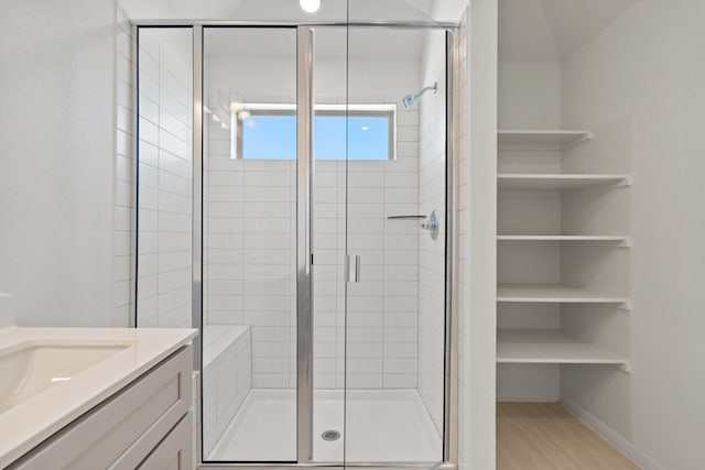 bathroom with vanity, hardwood / wood-style flooring, and a shower with door