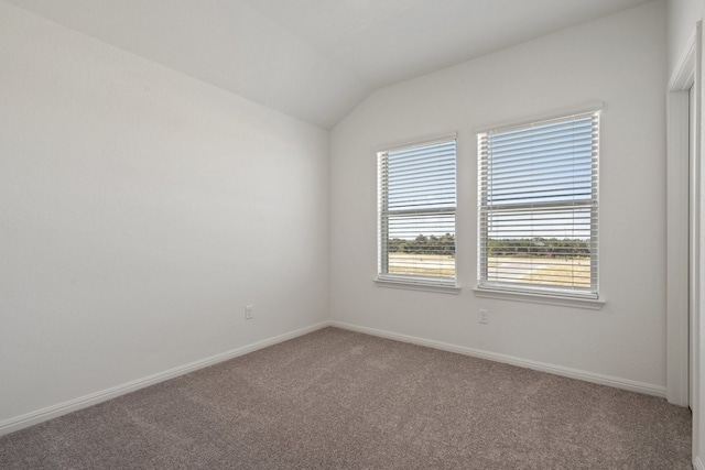 unfurnished room with carpet and vaulted ceiling