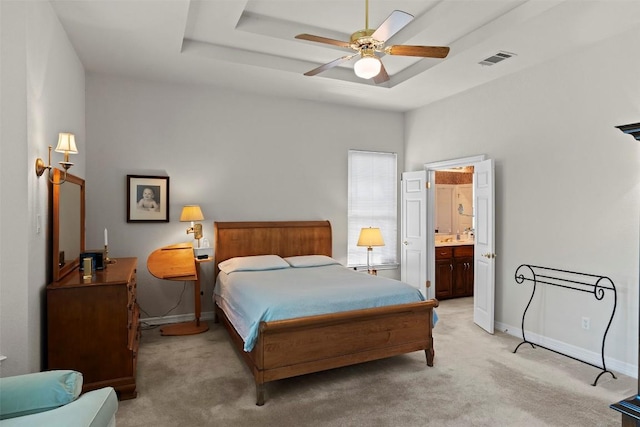 bedroom featuring baseboards, visible vents, a raised ceiling, and light colored carpet