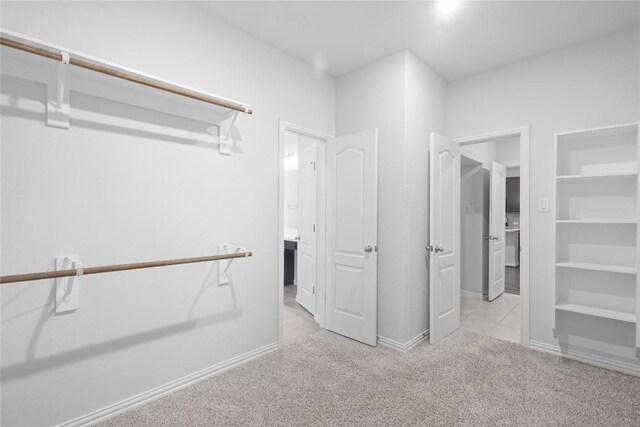 walk in closet featuring light carpet