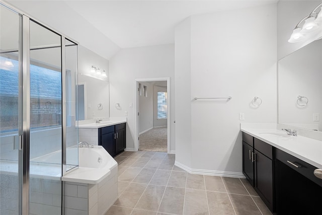 bathroom featuring tile patterned floors, vanity, and tiled bath