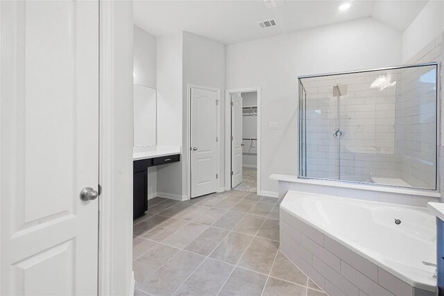 bathroom featuring tile patterned flooring, vanity, lofted ceiling, and shower with separate bathtub