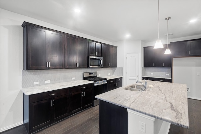 kitchen with backsplash, sink, appliances with stainless steel finishes, and decorative light fixtures