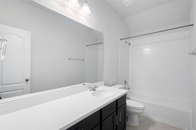 full bathroom with tile patterned floors, vanity, tiled shower / bath combo, and toilet