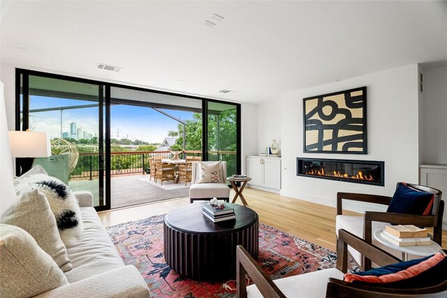 living room with expansive windows, hardwood / wood-style flooring, and plenty of natural light