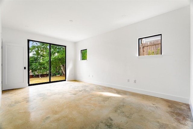 unfurnished room featuring baseboards and concrete flooring