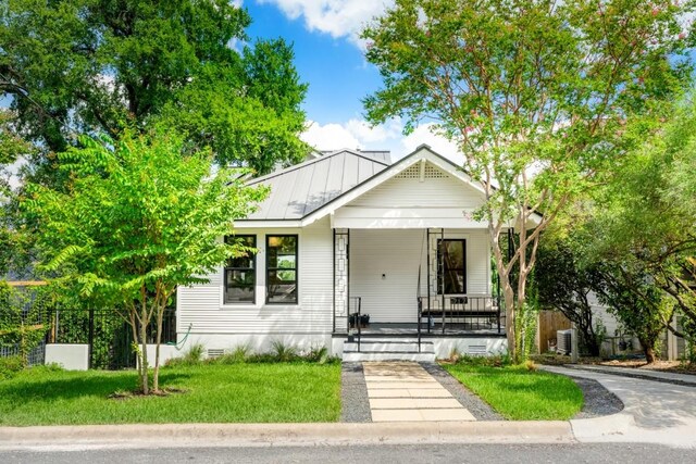 view of front of house with covered porch and a front lawn