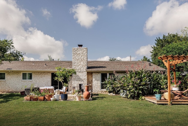 rear view of house with a wooden deck and a yard