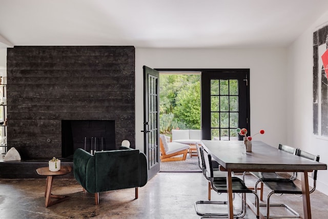 dining room with a fireplace and concrete floors